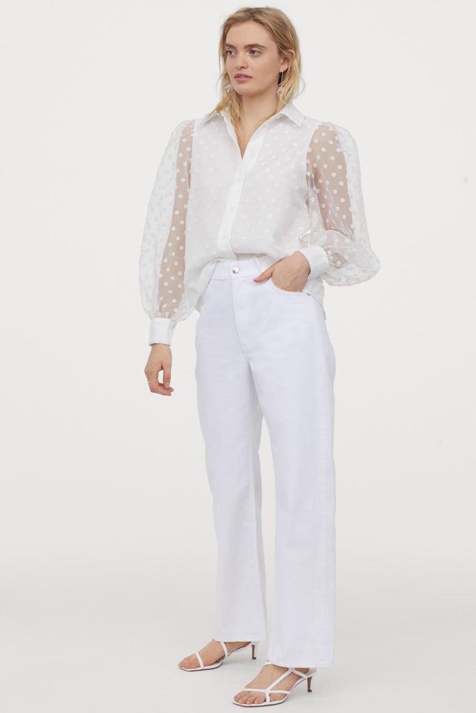 lady in white pants and white organza shirt with polka dot sleeves