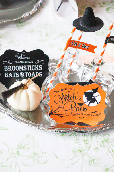 silver tray with white pumpkin glass bottles and buffet signs for halloween
