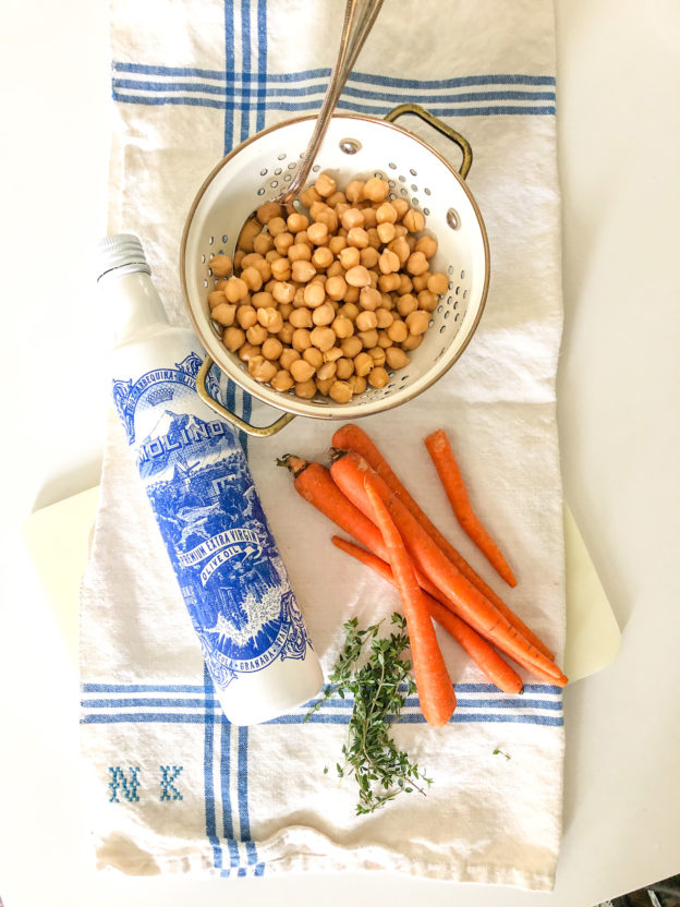 carros on a kitchen towel chickpeas in a bowl olive oil in a blue and white bottle