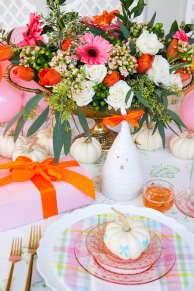 halloween place setting in pink and orange with white pumpkin ghost candle and gift box