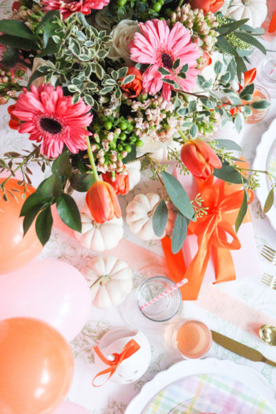 halloween table setting with white pumpkins pink and orange flowers and balloons