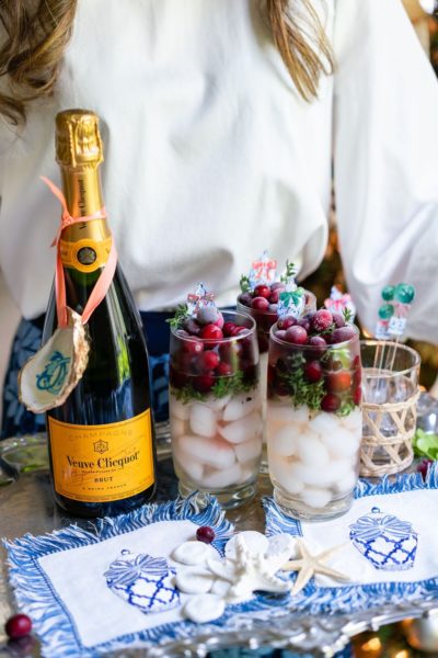 champagne cocktails with cranberries and napkins on a silver tray