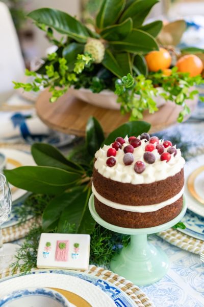 gingerbread cake with cranberries on top on blue and white table setting for christmas