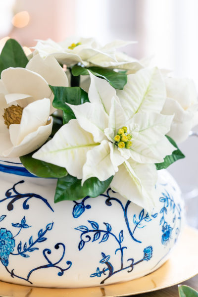 close up of poinsettia sugar flower in cake made to look like a blue and white chinoiserie vase