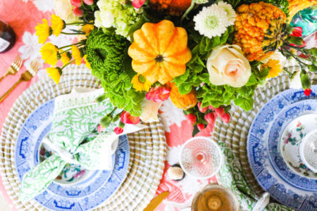 thanksgiving table setting overhead shot with pumpkins and flowers