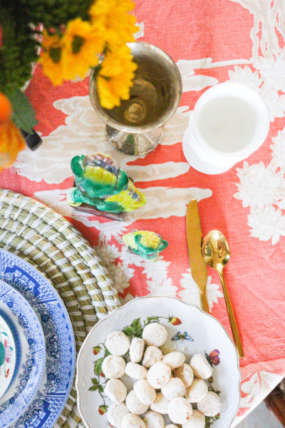 coral vintage table cloth with foo dogs cups plates flatware overhead shot