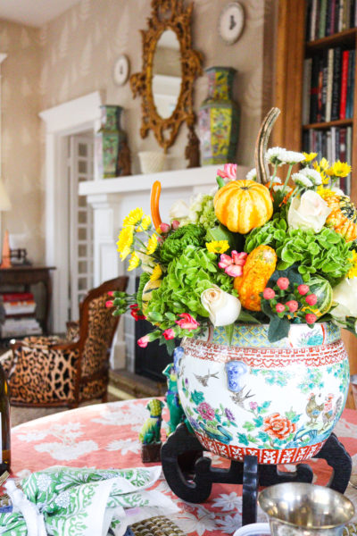 fall floral centerpiece in garden room with mantel and mirror in background