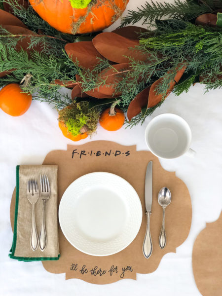 friendsgiving place setting with friends themed placemat white plate and large coffee mug