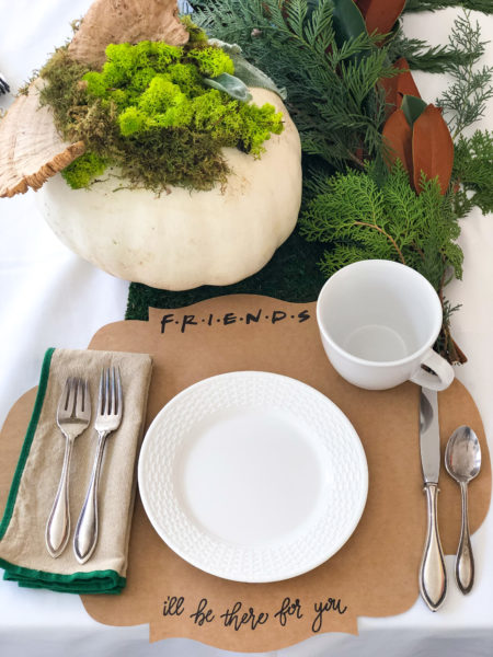 friendsgiving placesetting with brown placemat and white plate and white coffee mug