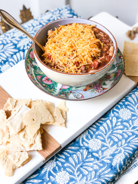 chili in a blow with cheese ontop and crackers on side of bowl
