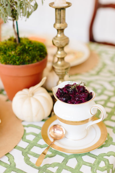 Cranberry Sauce with apples and grapes on thanksgiving table and white pumpkin