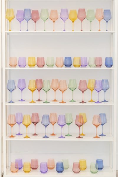 five white shelves with colored glasses