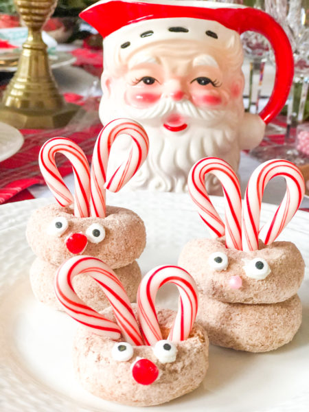 mini rudolph doughnuts with candy cane antlers and candy eyes and nose with santa pitcher in background