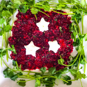 cranberry jalapeno dip with cream cheese stars and surrounded by cilantro
