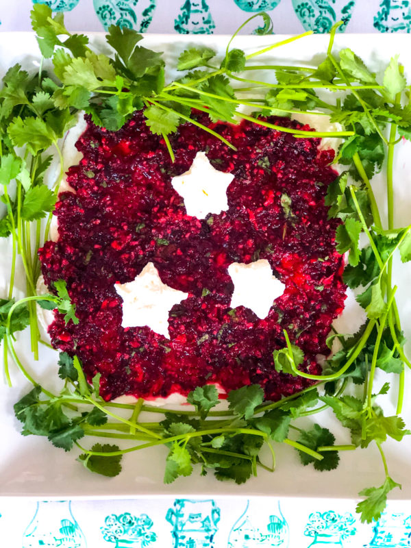 cranberry jalapeno dip with cream cheese stars and surrounded by cilantro