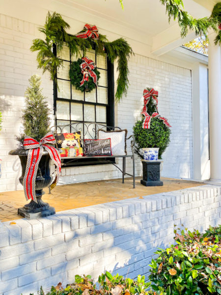 outdoor porch dressed for christmas with bench