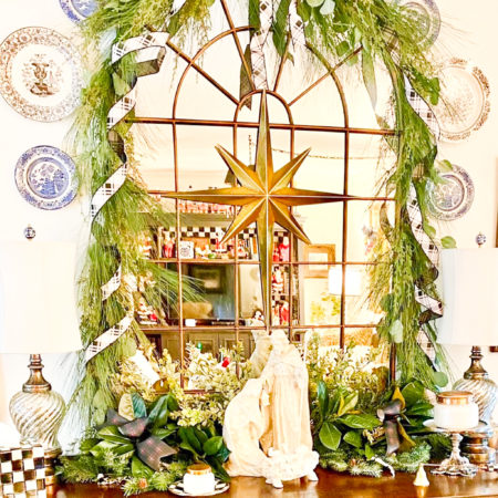 nativity scene on brown buffet table with star and greenery