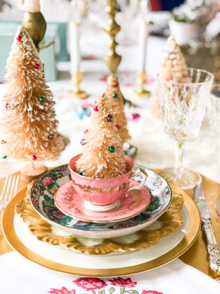 pink and gold christmas table setting with bottle brush trees