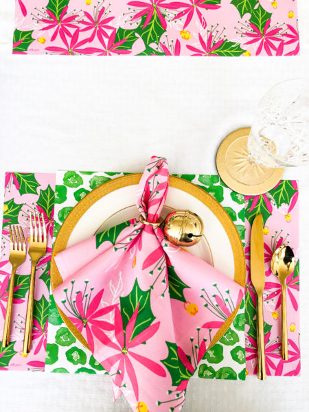 table setting with pink poinsettia and green leopard print placemats and napkins