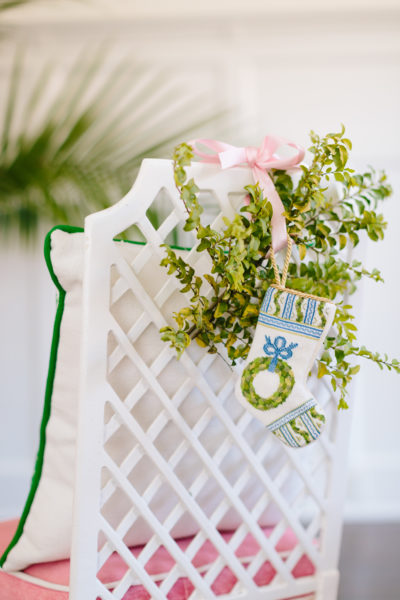 white lattice back chair with greenery and mini bauble stocking on back