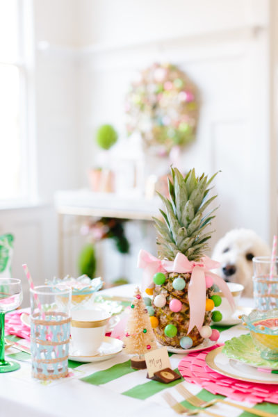 white dog looking at table and pineapple with gum balls