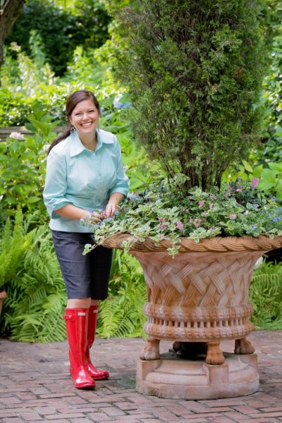 carmen johnston with large planter and wearing red boots