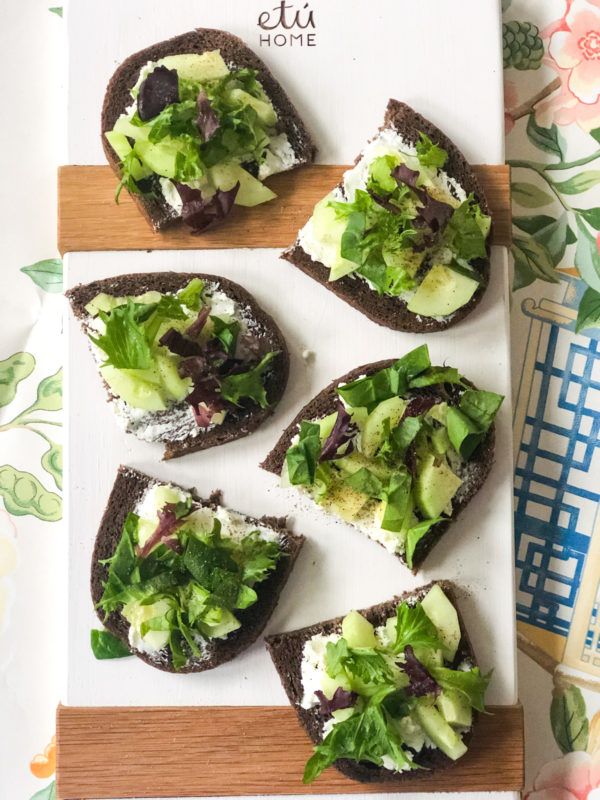 cucumber sandwiches with spring greens on white chopping board