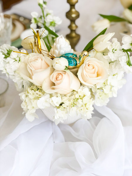 white flowers in a white pot with gold and blue bird