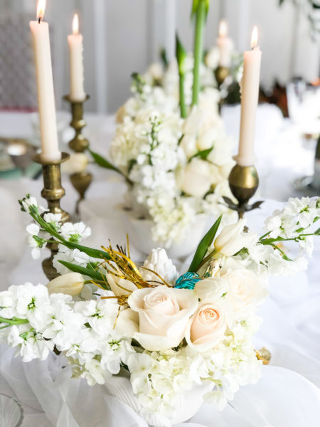 white flowers on white table with white candles