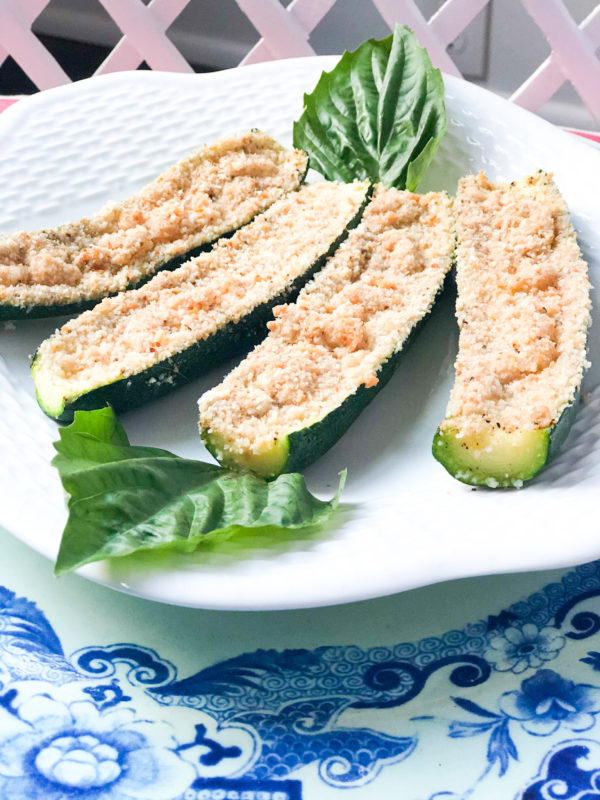 baked breaded zucchini on white plate with basil garnish