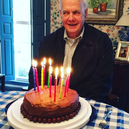 grandfather with chocolate birthday cake and tall candles