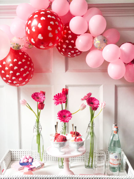 valentines day bar cart with balloon garland and pink flowers