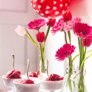 gelato served on pink cake stand with flowers and balloons for valentines day