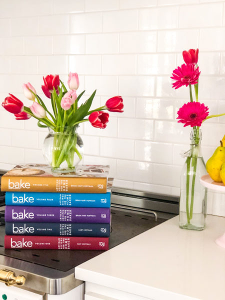 bake from scratch cookbooks stacked with tulips on top