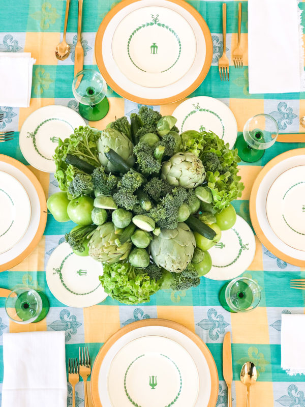tableset with green teal yellow tablecloth and green flower arrangement