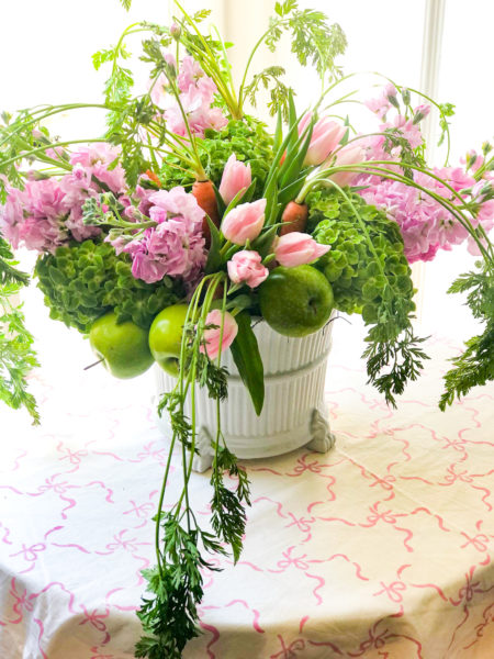 floral arrangement with flowers apples and carrots