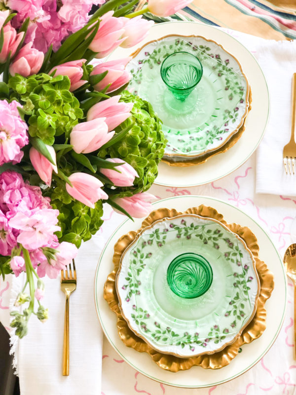 green table setting for two with pink flowers