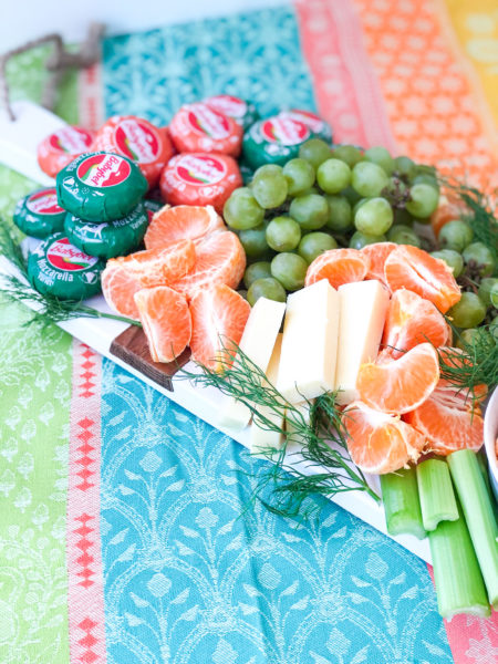 st patricks day charcuterie board with cheese oranges grapes and celery