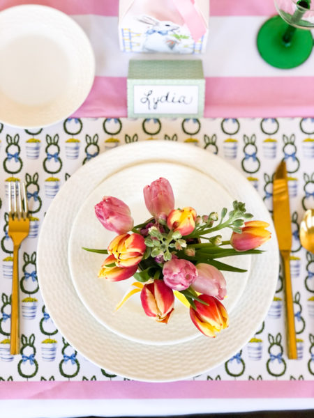 overhead shot of white plates on bunny topiary placemats with tulips on plates