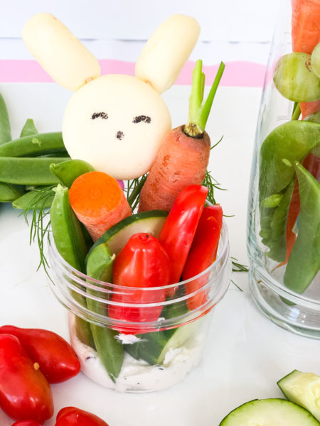 Easter jarcuterie with carrots tomatoes snow peas and cheese shaped like a bunny