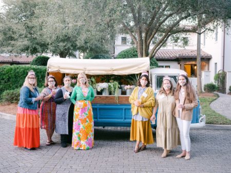 citrus party hosts in front of blue flower truck
