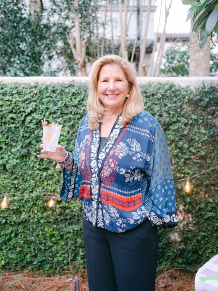 leslie chalfont of giddy paperie holding cocktail by ivy wall