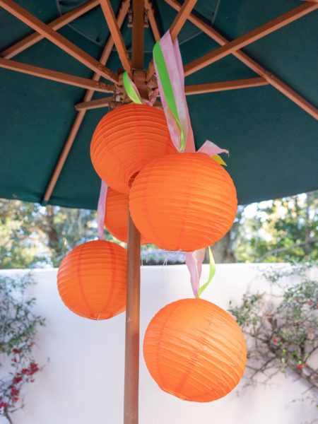 citrus party orange paper lanterns hanging from umbrella