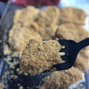 cornflake friend chicken on black spatula in clear dish