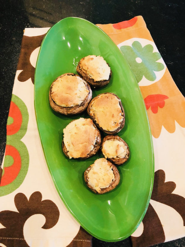 mushroom bites with cheese on top on a green plate