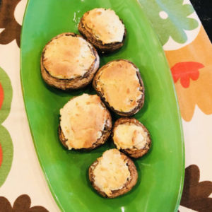 mushroom bites with cheese on top on a green plate