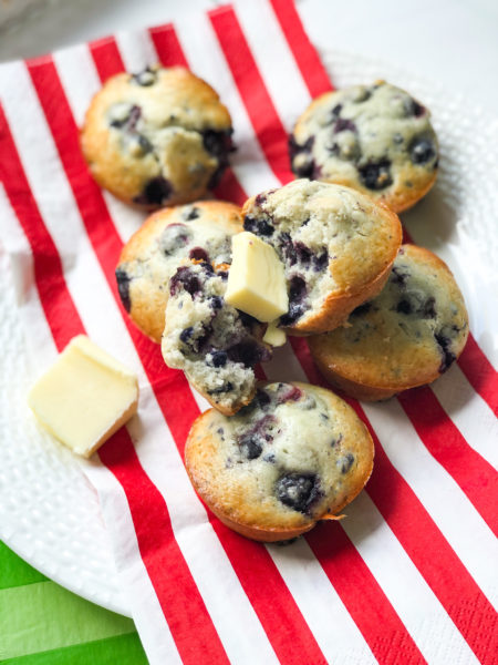 blueberry muffins with putter on red and white striped napkin