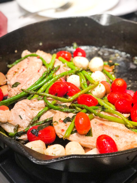 mediterranean chicken with tomatoes asparagus in cast iron skillet