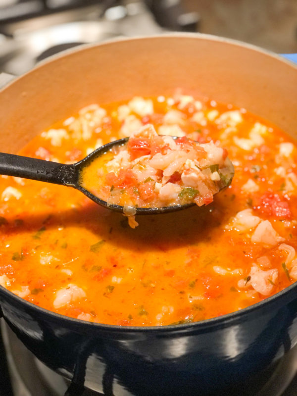tomato shrimp feta soup being ladled from pot