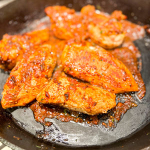 chicken ole with salsa and mustard marinade in cast iron skillet